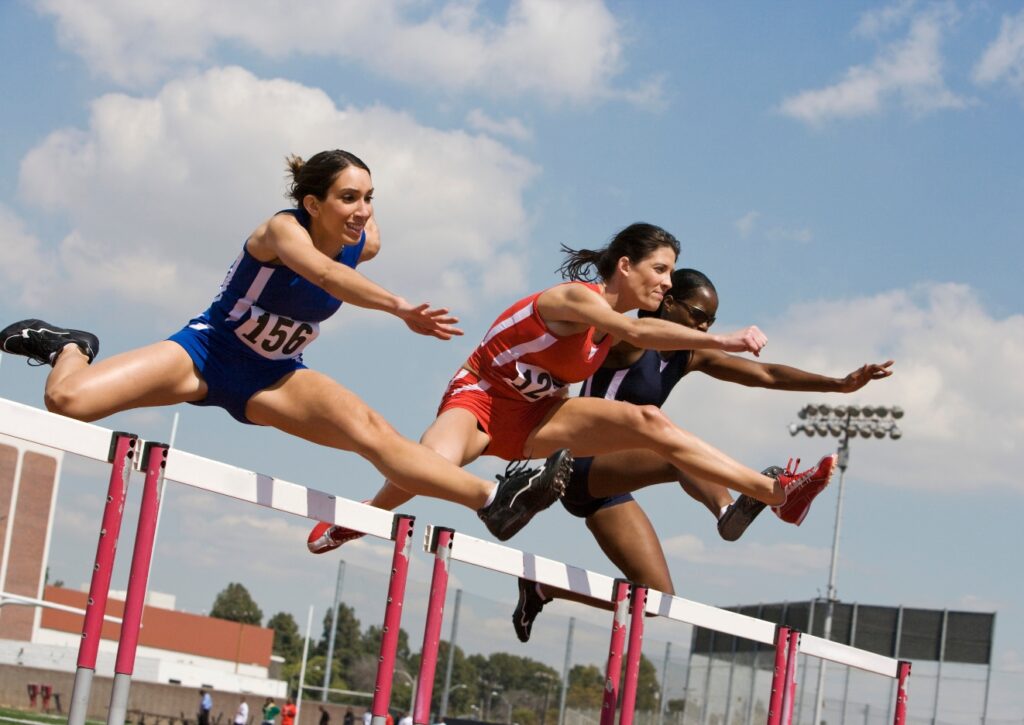 female athletes competing in hurdles