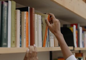 person picking a book up in a library