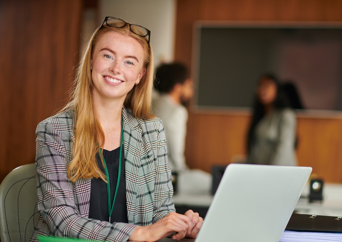 woman smiling next to her laptop